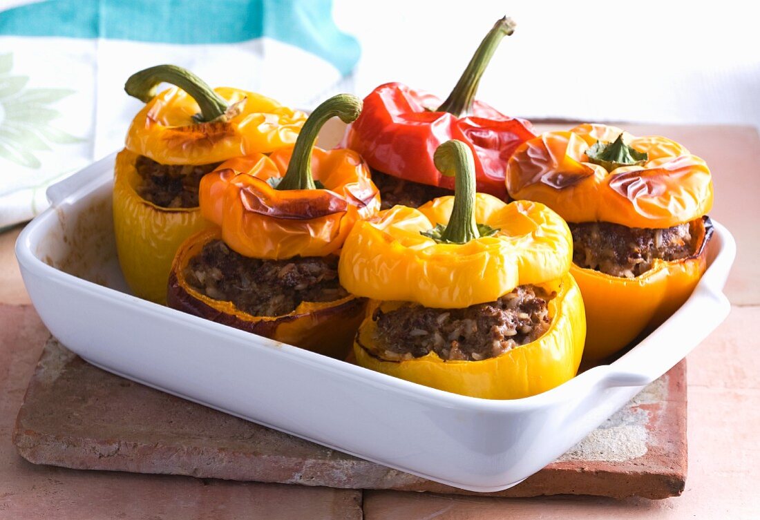 Peppers filled with minced meat and rice in a baking dish