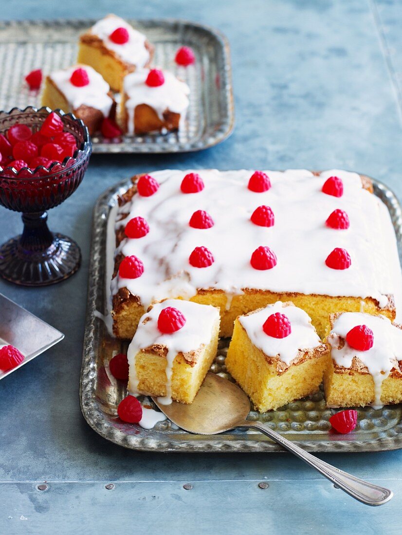 Tray-bake cake decorated with icing sugar and raspberries
