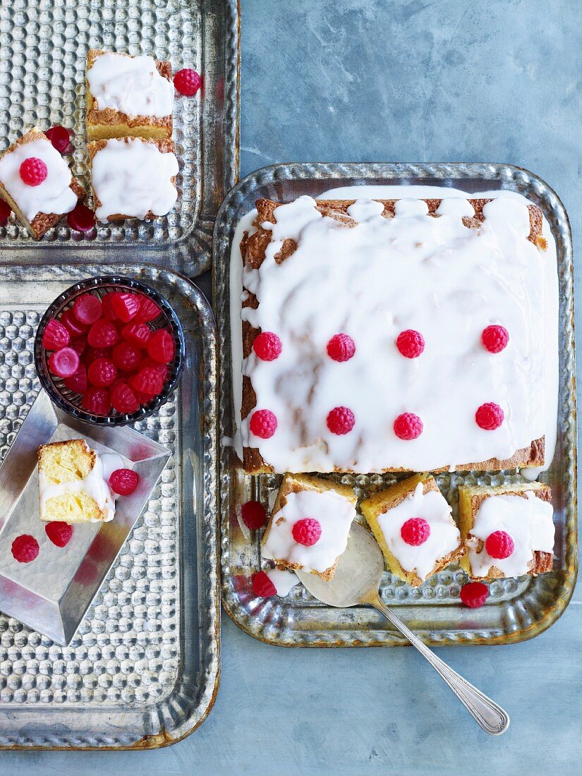 Tray-bake cake decorated with icing sugar and raspberries (seen from above)