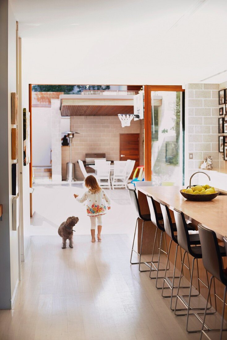 Little girl and dog in open-plan kitchen with plenty of seating at counter