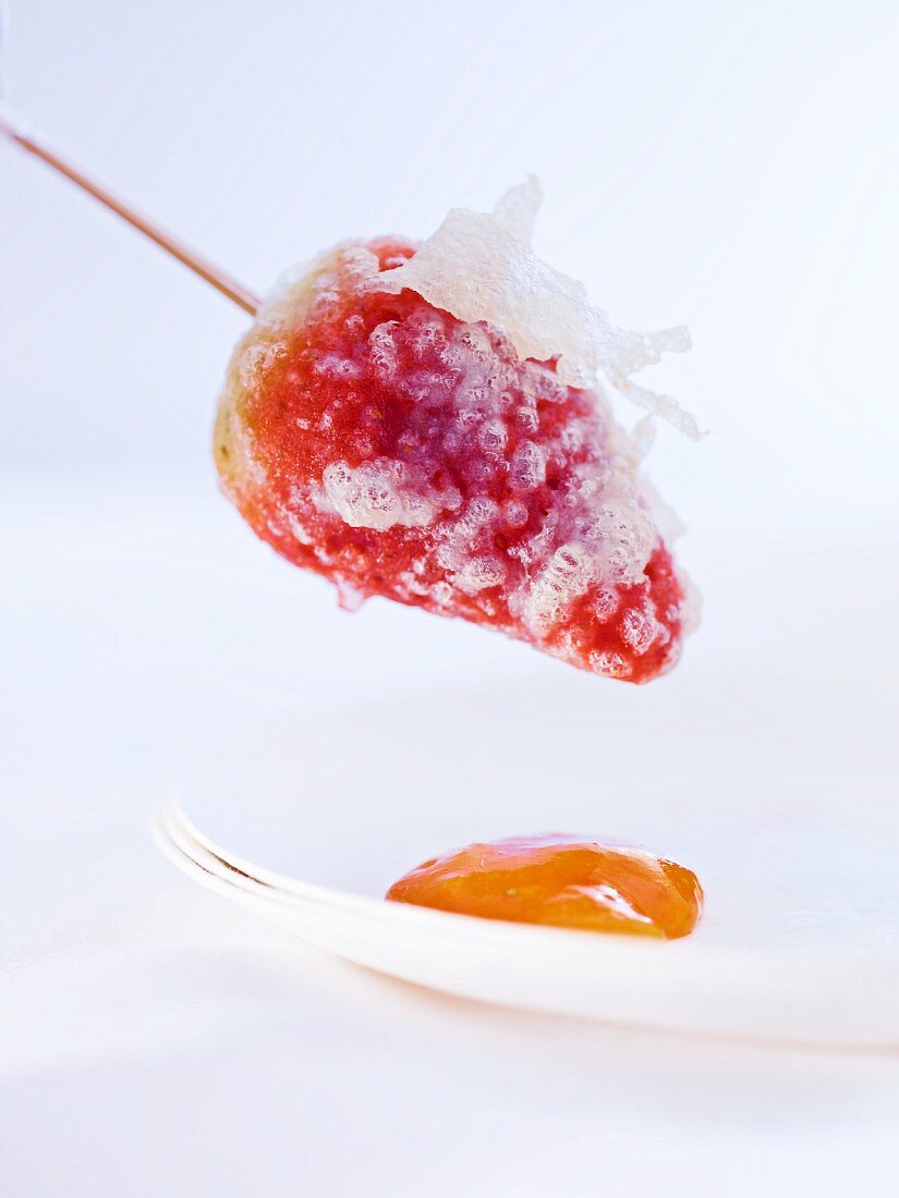 A strawberry in tempura batter with mango sauce