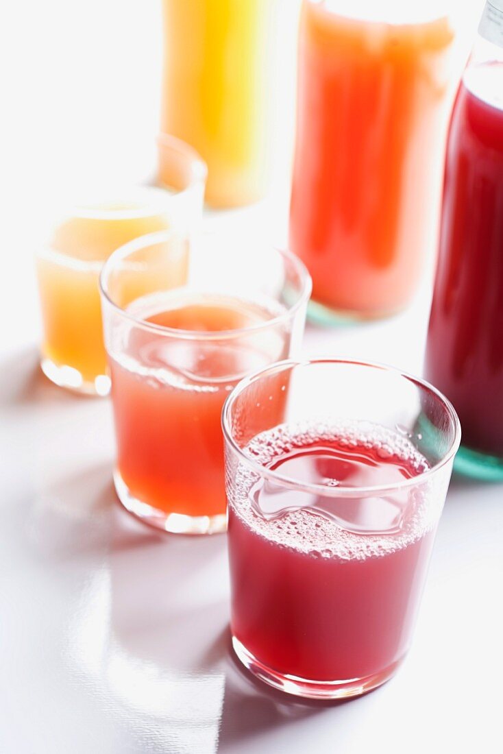 Various types of juice in bottles and glasses
