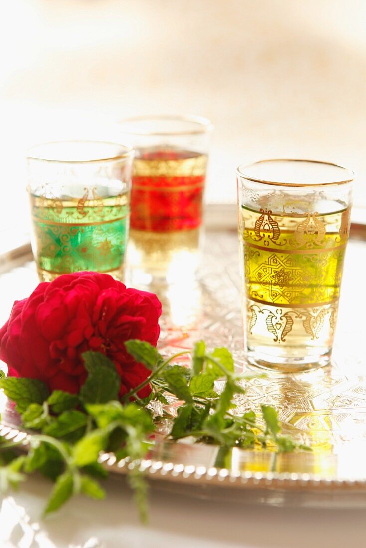 Peppermint tea, flowers and mint leaves on a silver tea tray