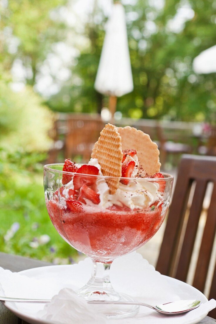A strawberry dessert with whipped cream and wafers
