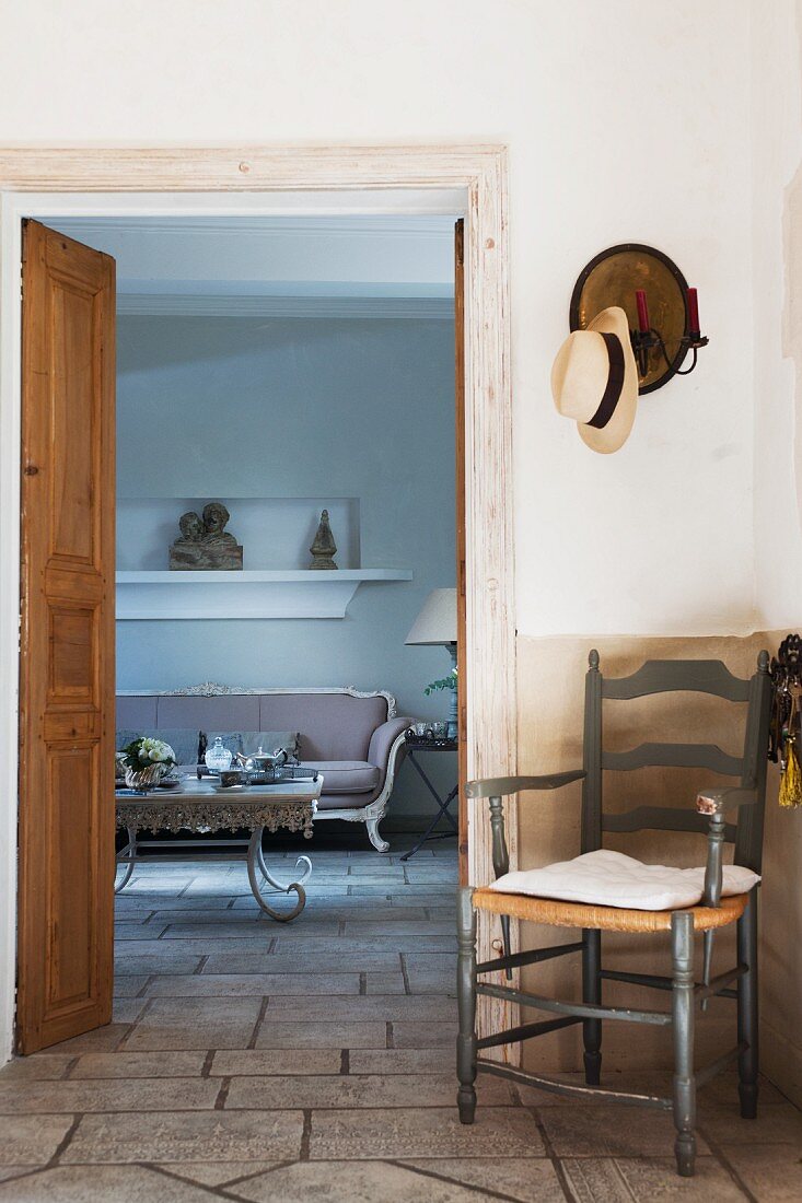 View into salon with Baroque furniture from foyer with wooden chest of drawers