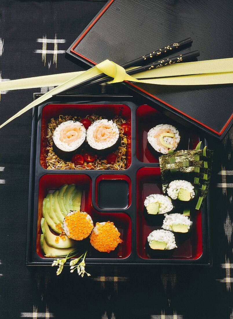 Mehrere verschiedene Sushi in eckigen Schalen angerichtet