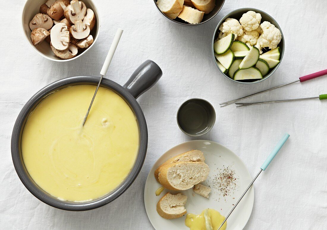 Cheese fondue with white bread and vegetables