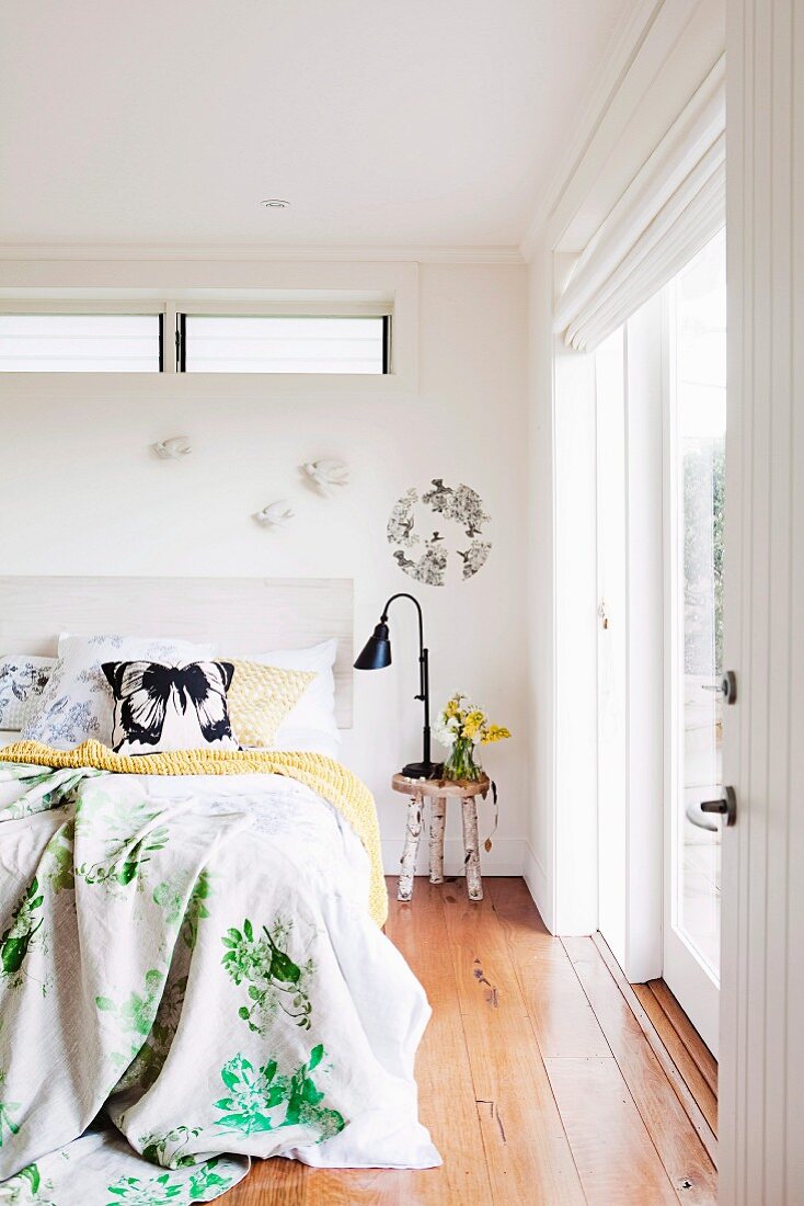 Double bed and birch-log side table in bedroom