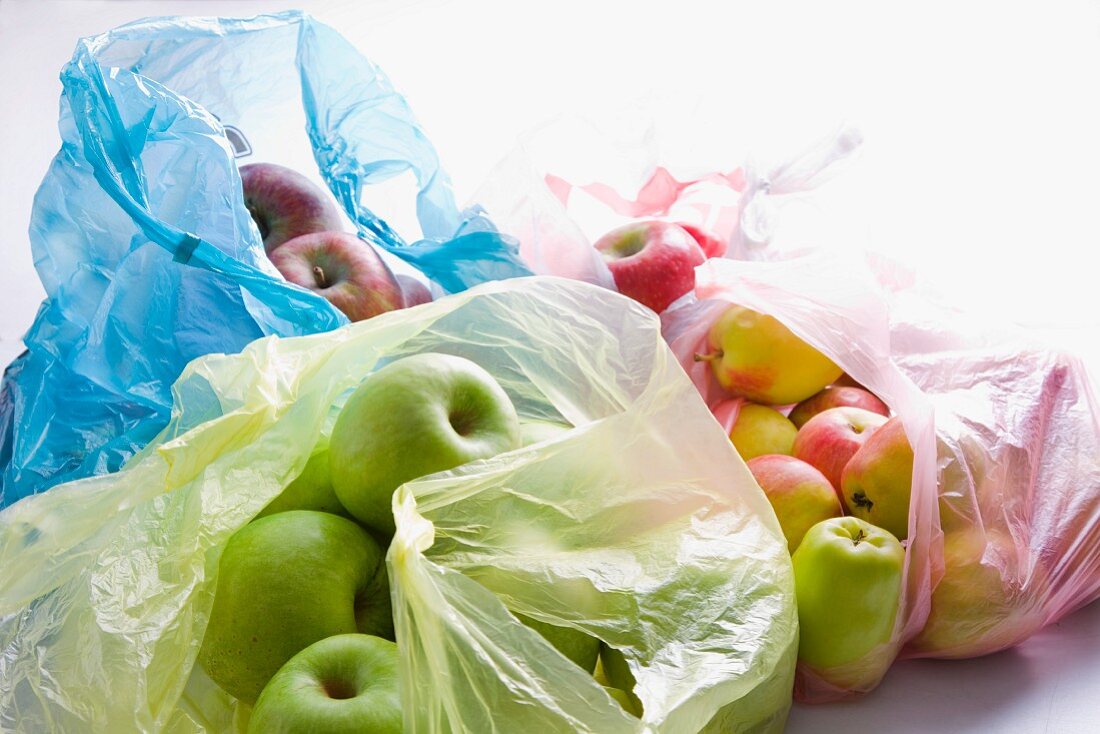 Verschiedene Sorten Äpfel in Plastiktüten