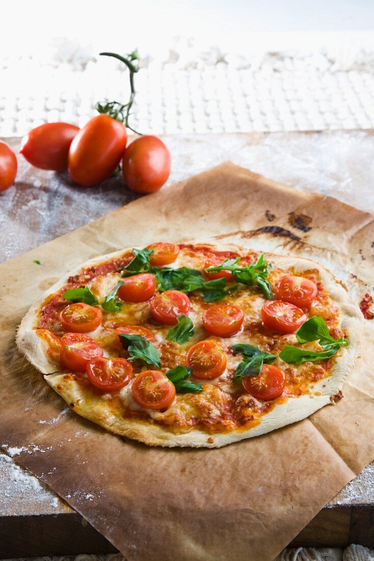 A pizza topped with cherry tomatoes and basil