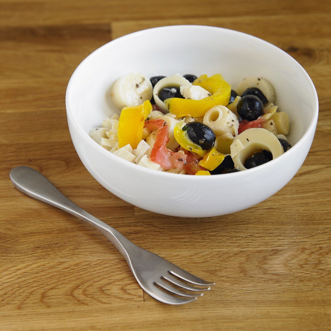 Hearts of Palm Salad with Olives and Sweet Peppers in a Bowl; Fork