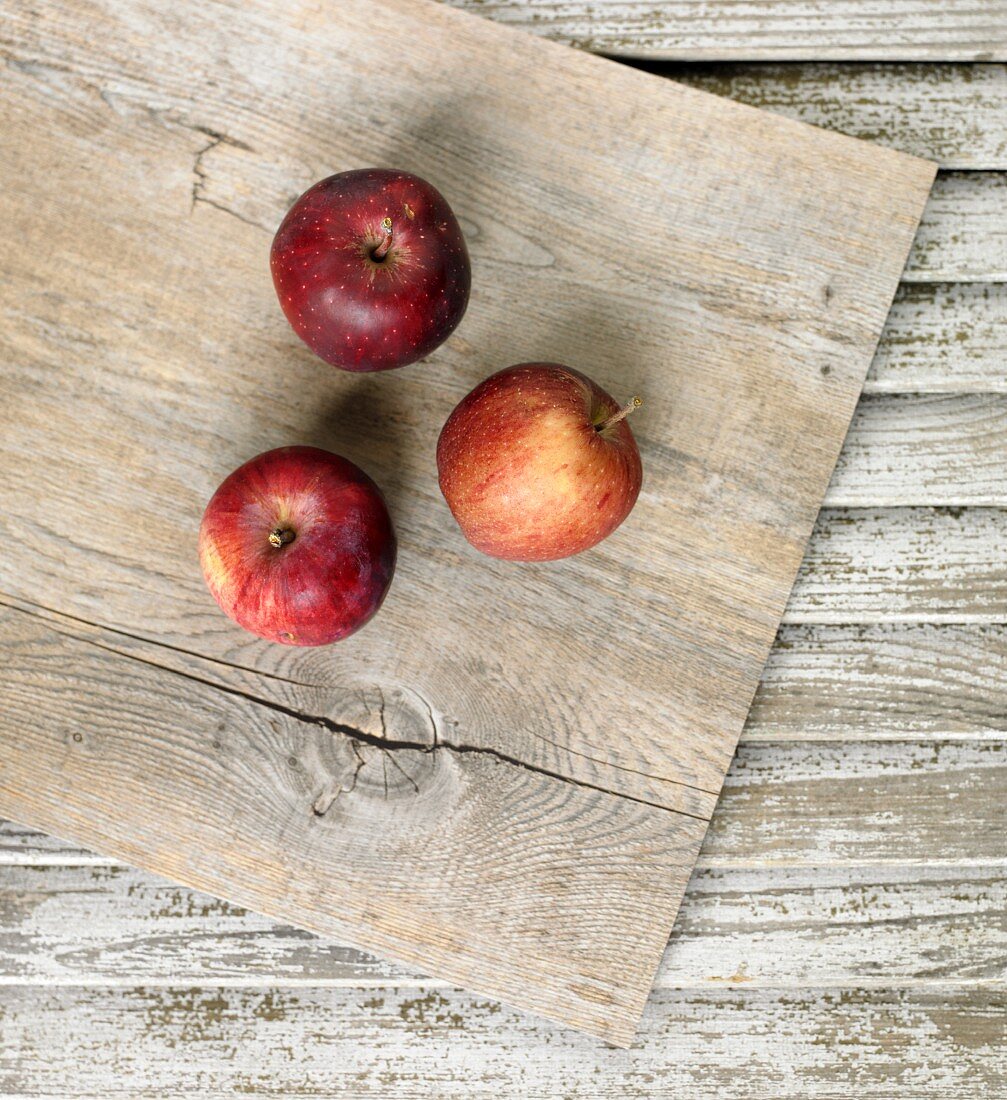 Three Fresh Massachusetts Apples on Wooden Board