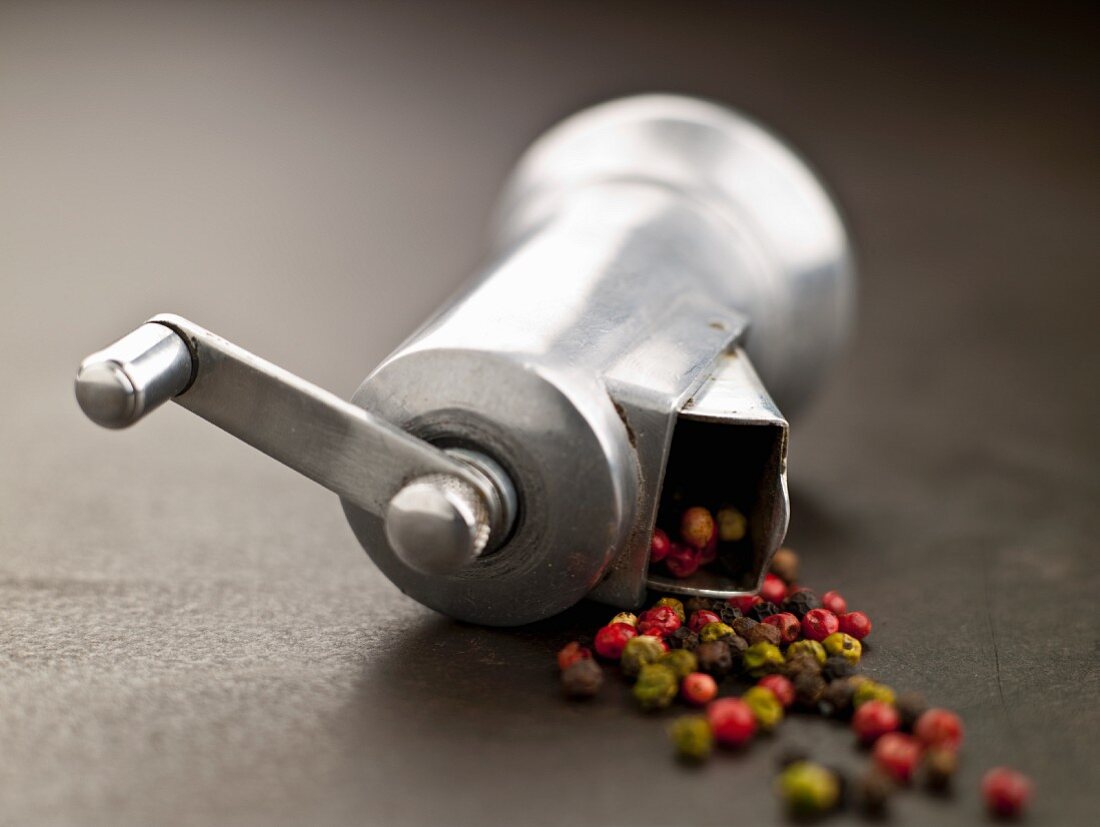 Multi-Colored Peppercorn Spilling From a Pepper Grinder