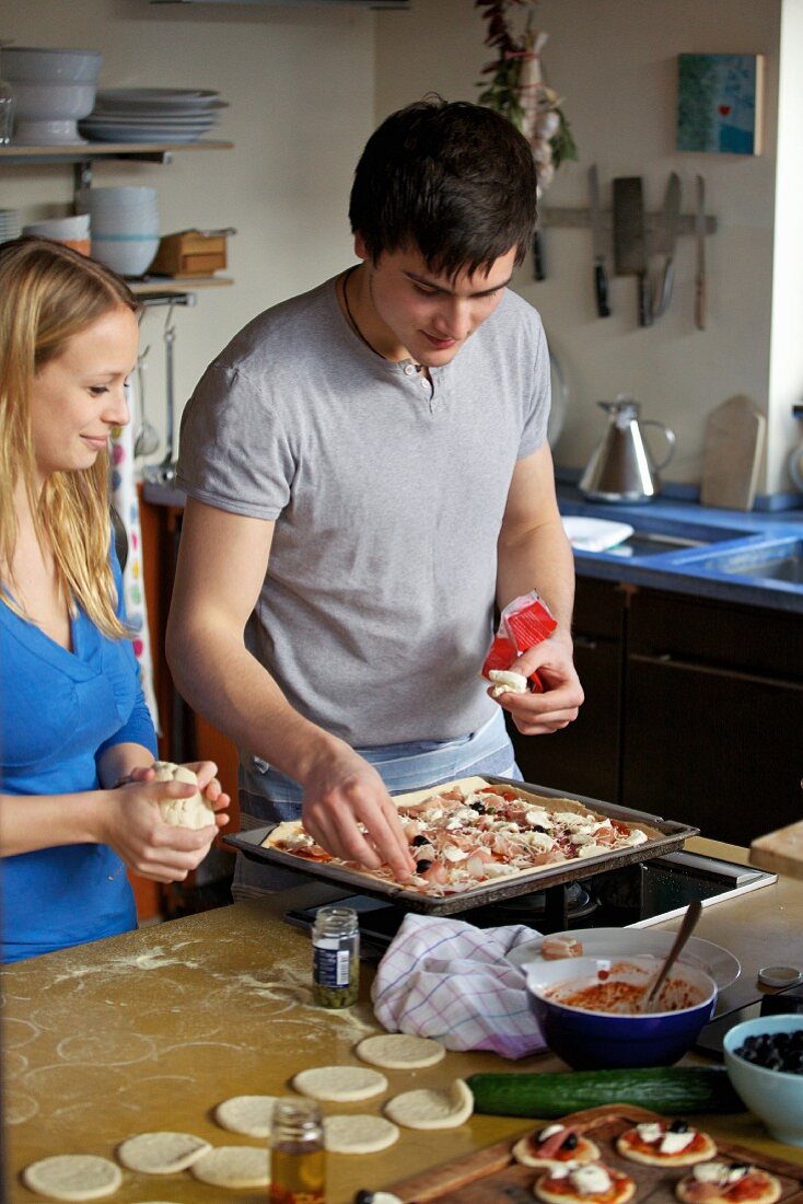 Junge Frau und junger Mann beim Pizzabacken