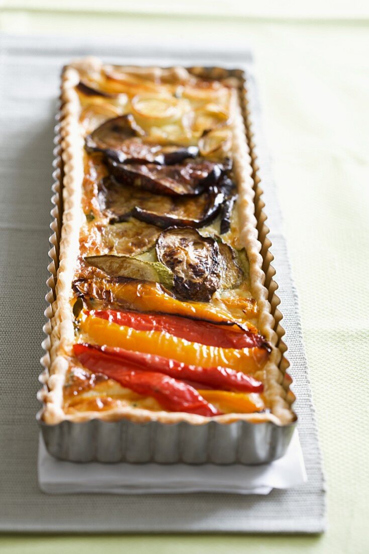 Quiche with antipasti vegetables in a baking tin