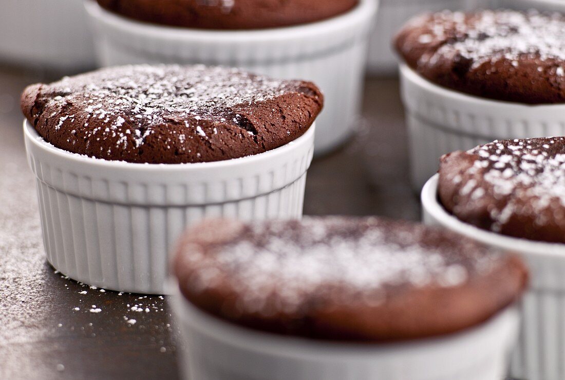 Mehrere Schokoladensouffles mit Puderzucker