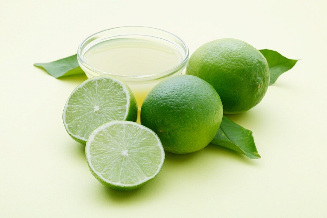 A bowl of lime juice and fresh limes