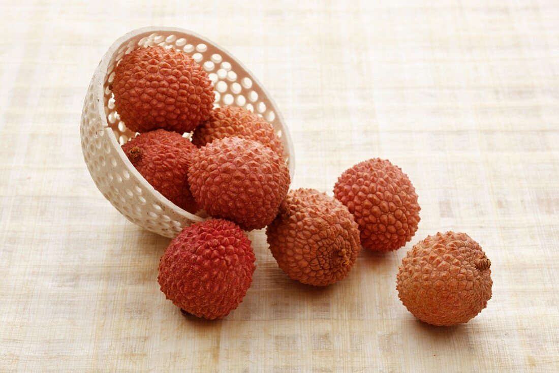 Lychees falling out of a bowl