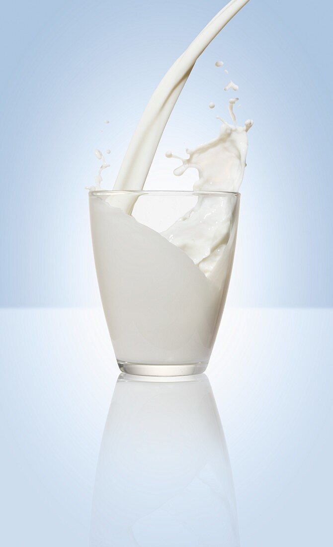 Milch in ein Glas einschenken