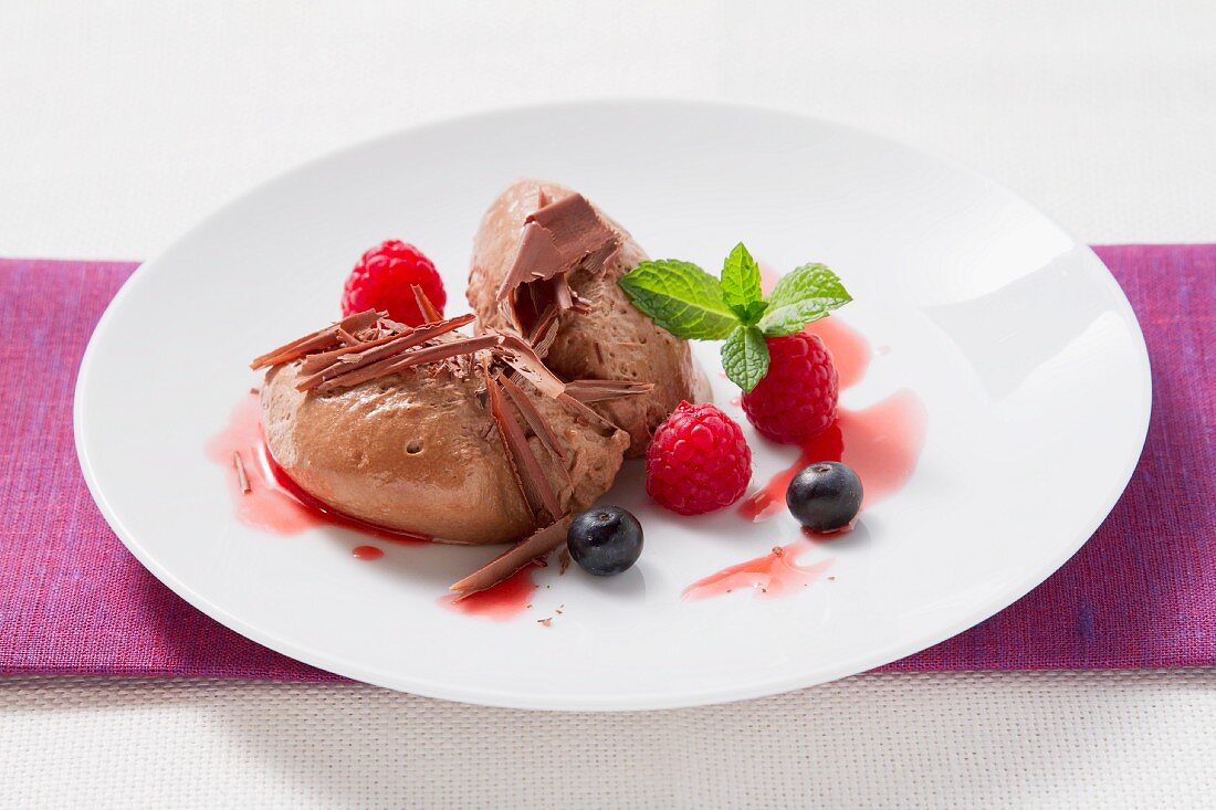 Mousse au chocolat garnished with fresh berries and mint
