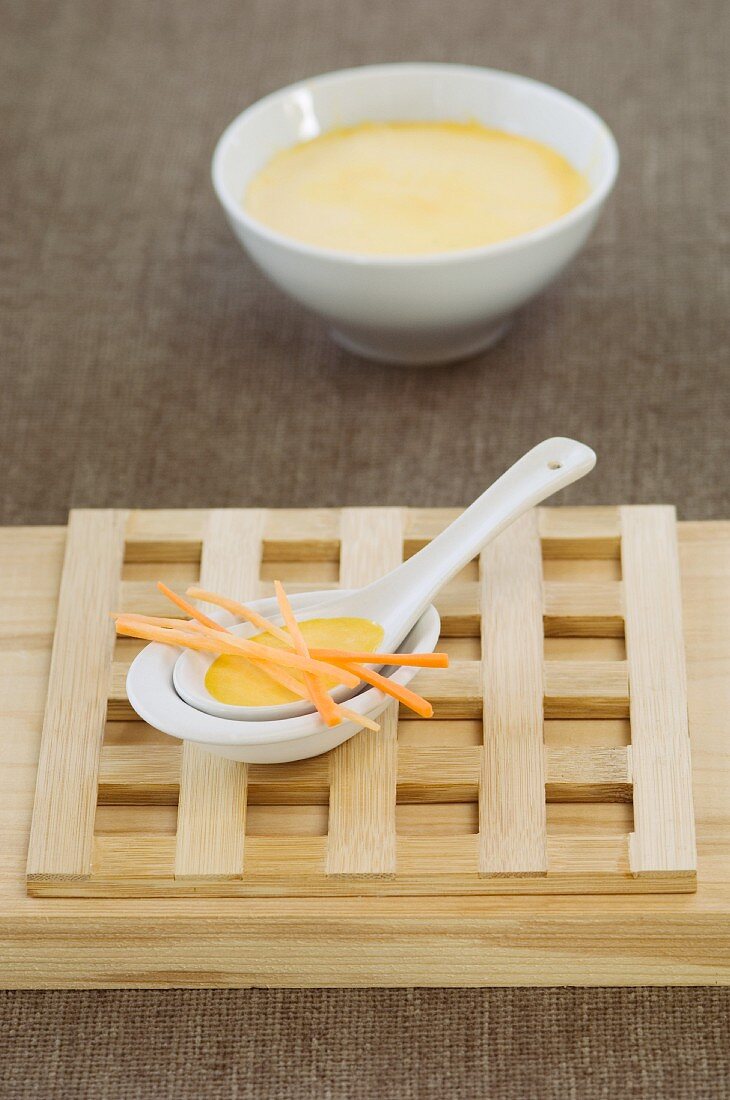 Carrot soup with carrot strips on an Oriental spoon