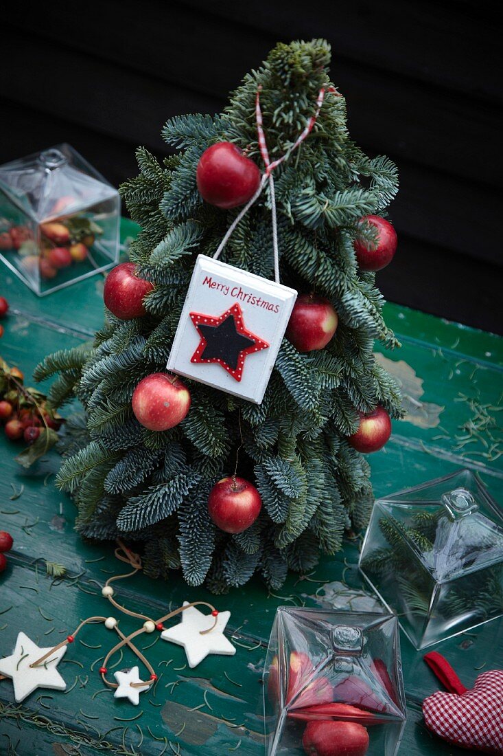 Christmas tree with red apples and Merry Christmas sign