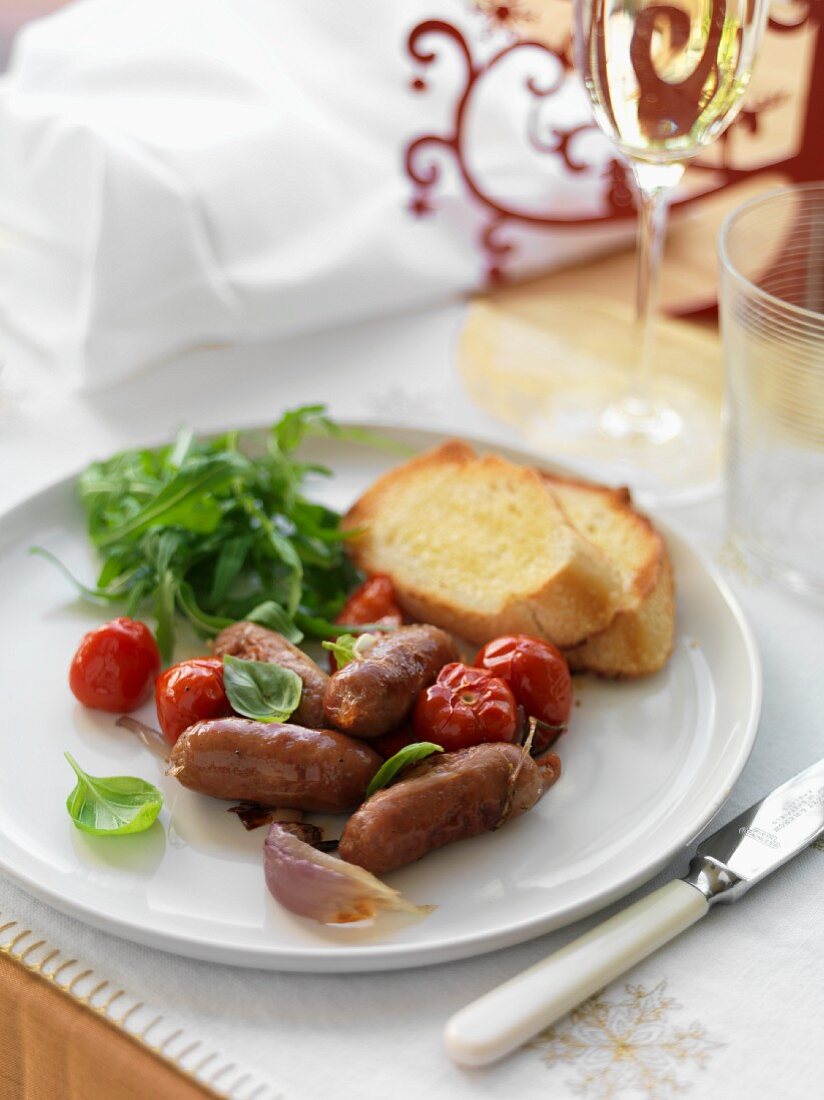 Bratwürstchen mit Tomaten und Knoblauchbrot