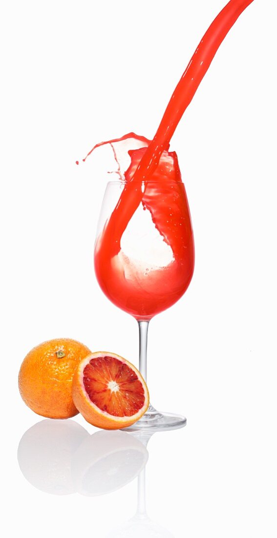 Blood orange juice being poured into a glass