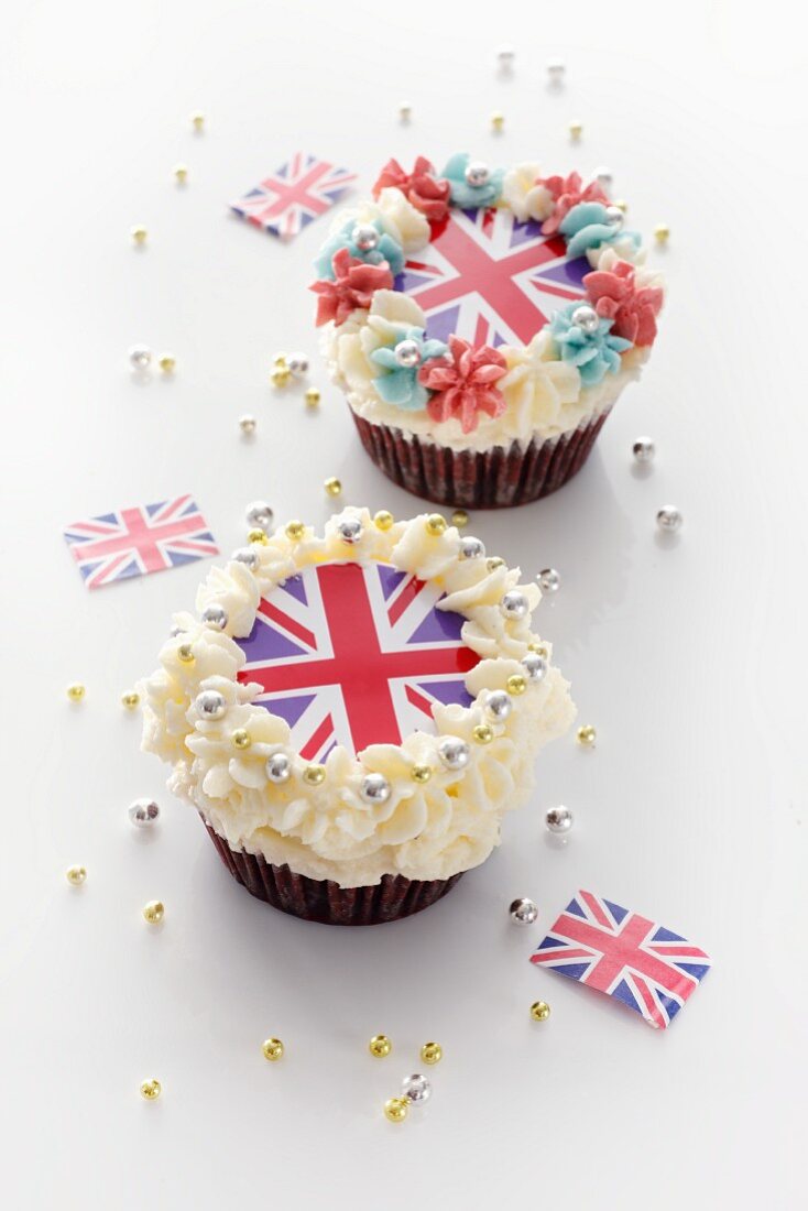 Two cupcakes topped with cream and Union Jacks