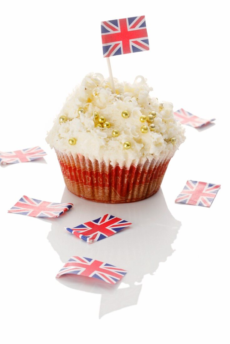 A cupcake decorated with golden beads and a Union Jack