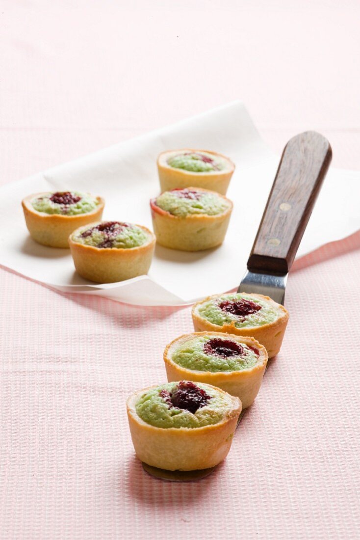 Almond, pistachio and marzipan tartlets topped with raspberries