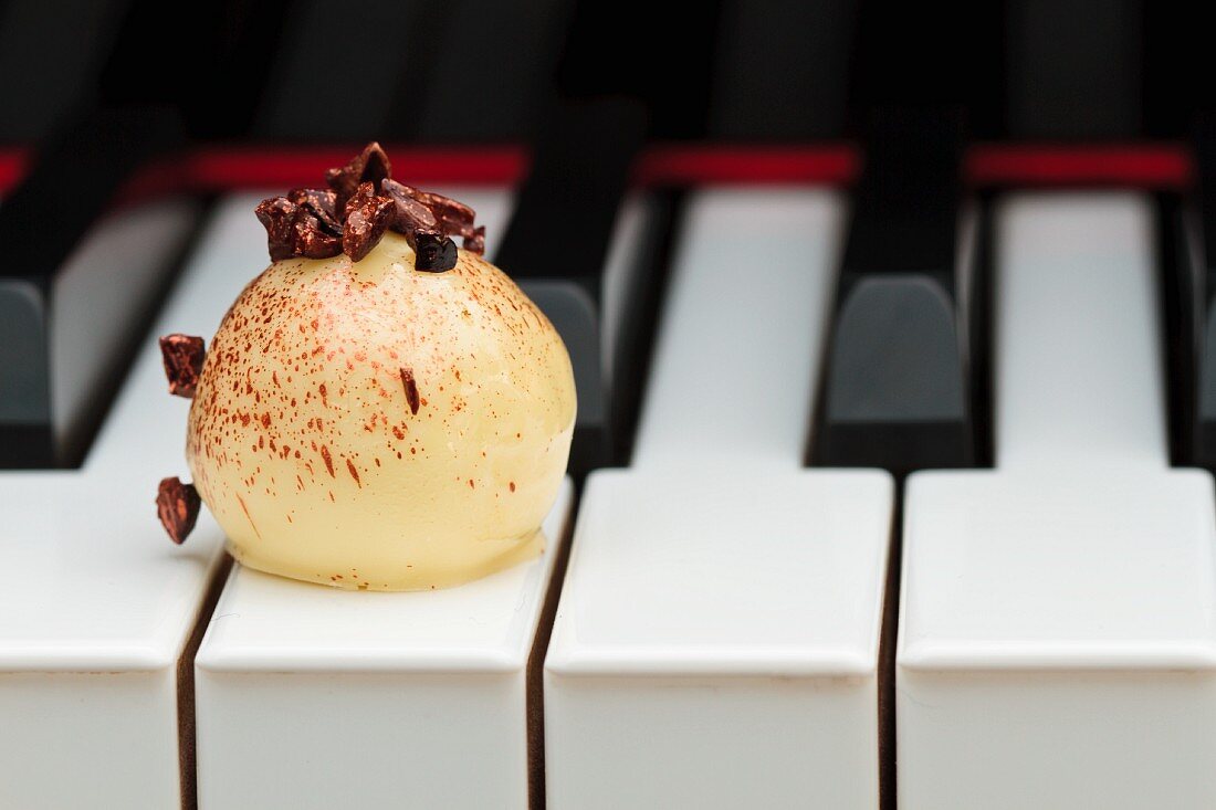 A white chocolate praline on a piano