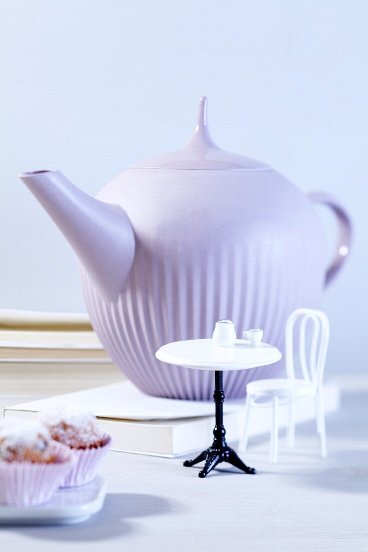 A teapot with doll's furniture and muffins