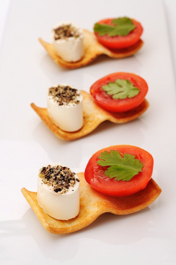 Canapes with cream cheese, tomatoes and coriander