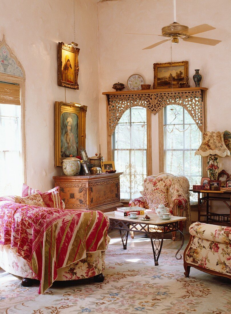 Romantic, antique sitting area with floral upholstered furniture and vintage chest of drawers in front of a lattice window with an oriental touch