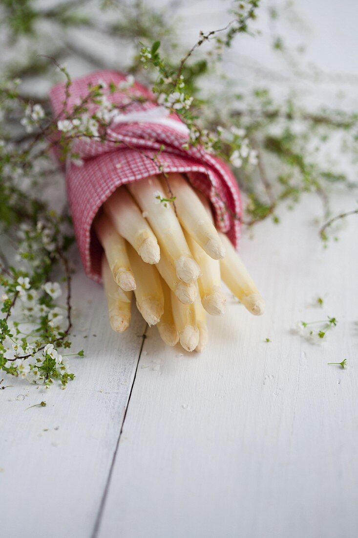 Pealed asparagus wrapped in a tea towel with gysophilia