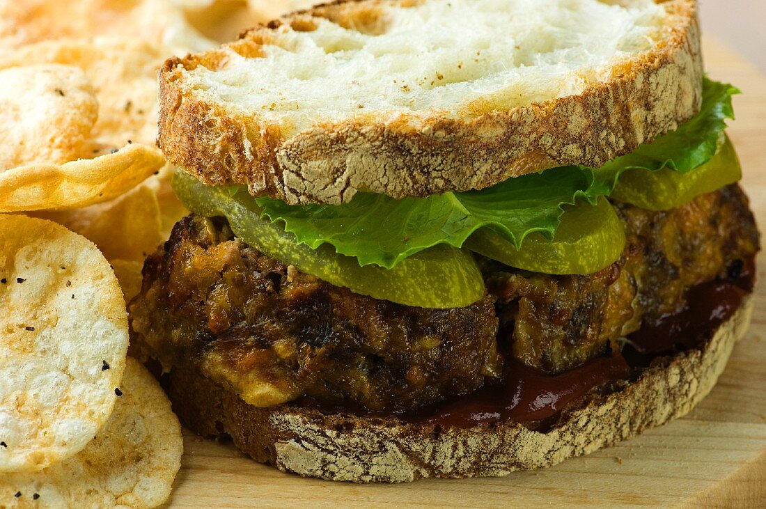 Meatloaf Sandwich on Country Bread with Ketchup, Lettuce and Pickles; Potato Chips