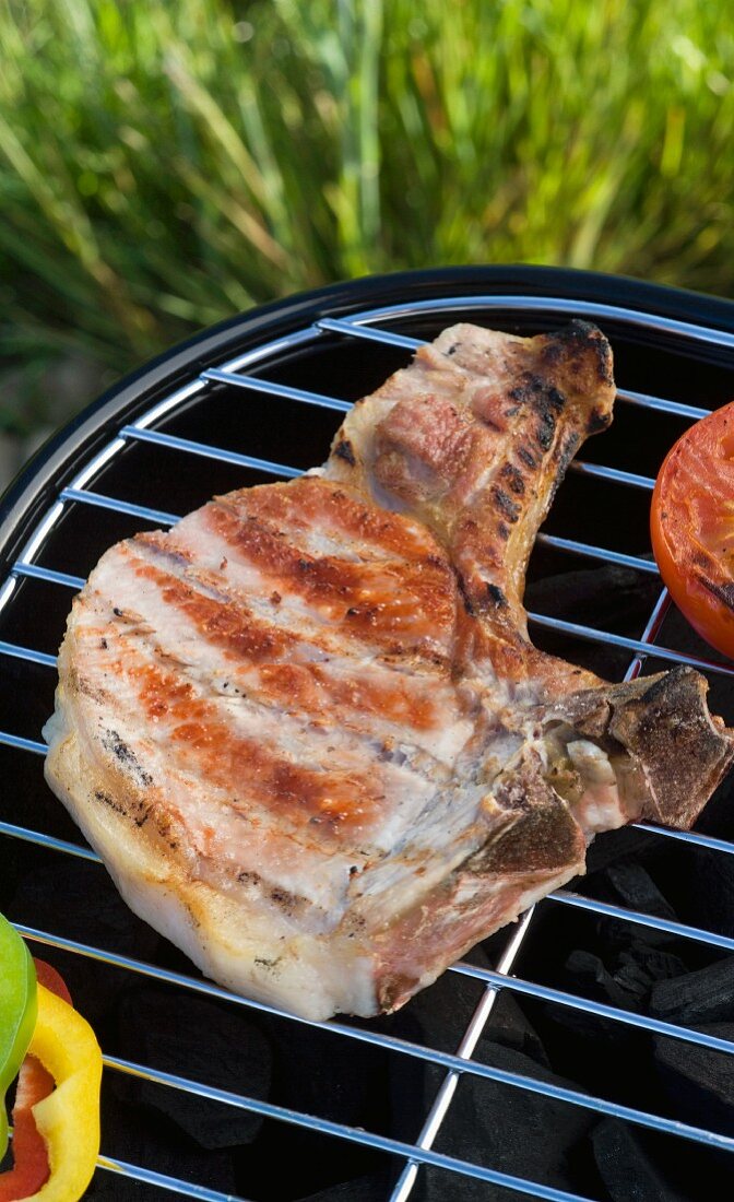 A grilled pork chop on a barbecue