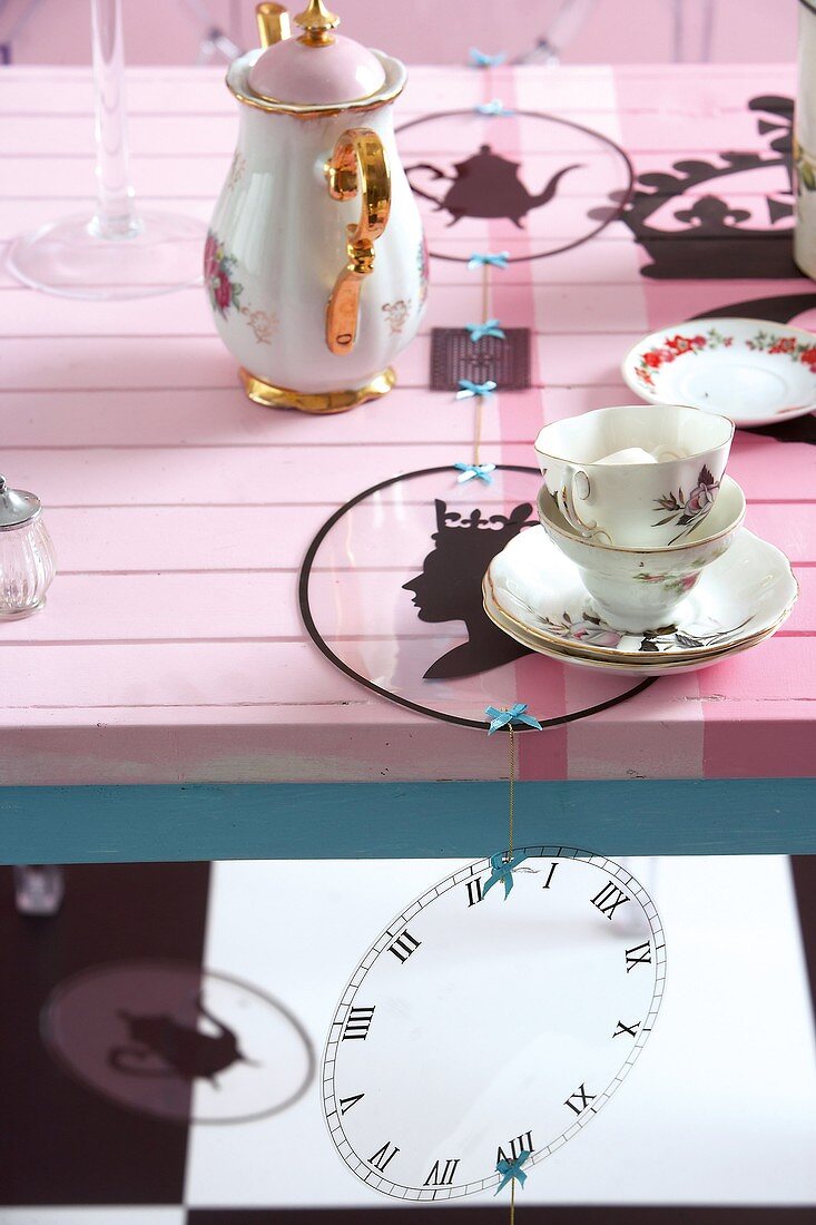 Tischläufer mit Silhouetten auf rosa Holztisch