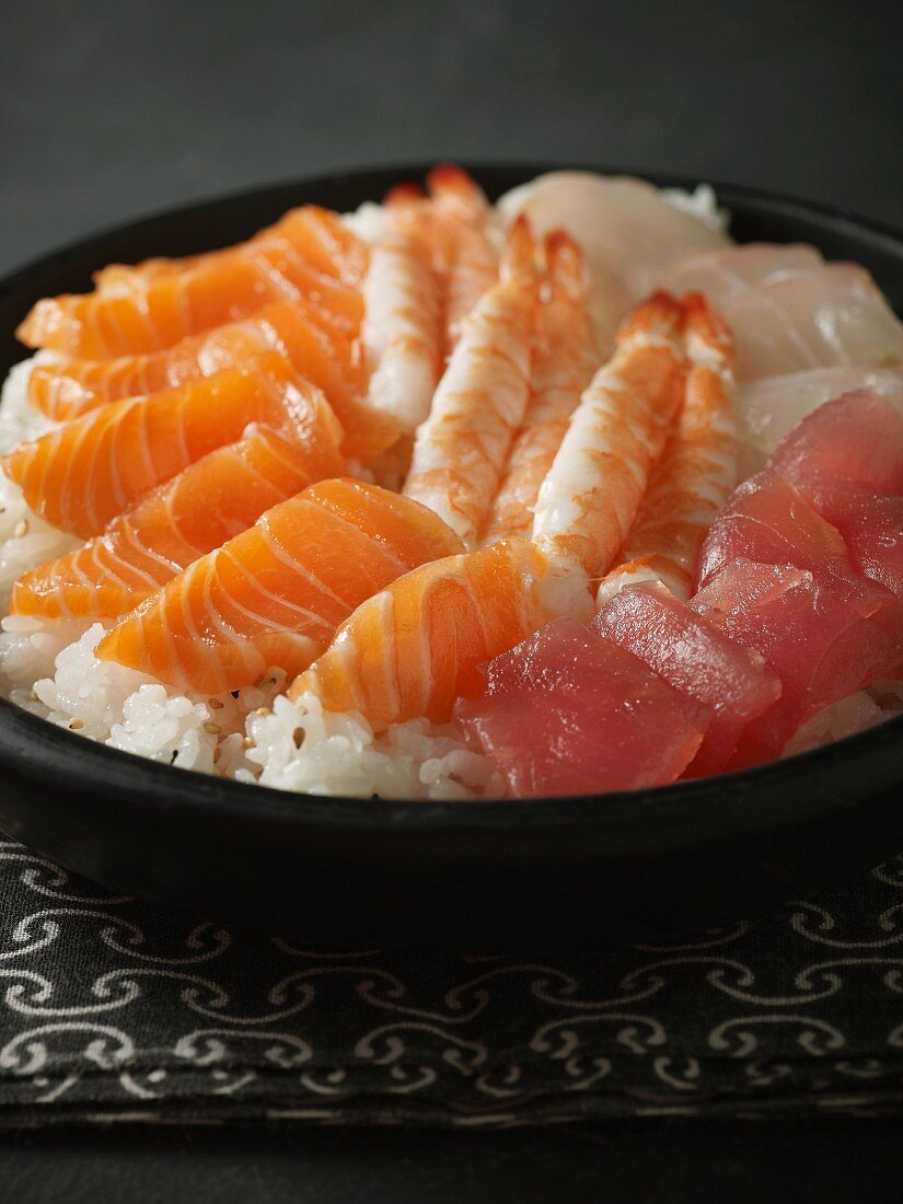 Rice, fish and seafood as ingredients for sushi in a bowl