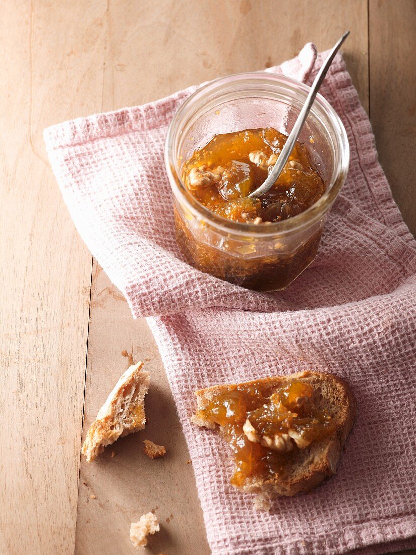 Fig and walnut jam in a glass and on a slice of bread