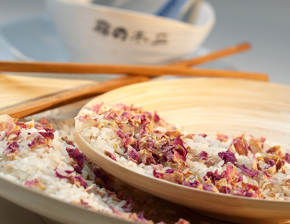 Dried flower petals and rise in a wooden bowl
