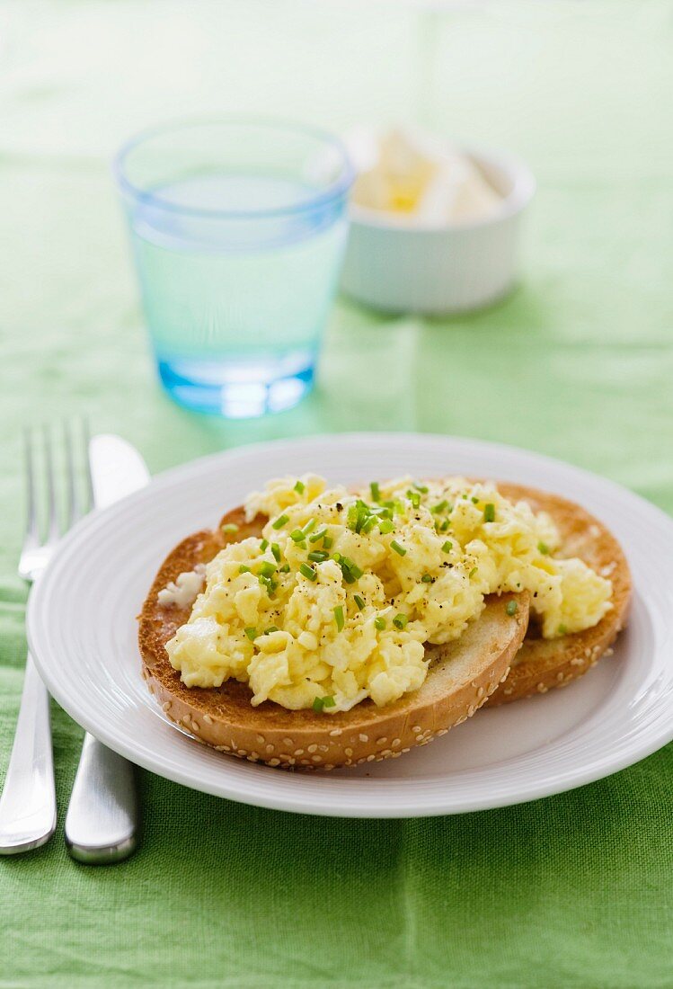 Scrambled eggs with chives on a toasted bagel