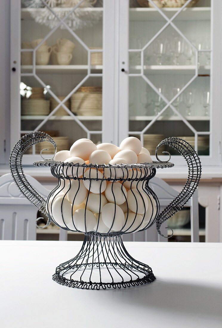 White Eggs in a Wire Basket on Kitchen Table