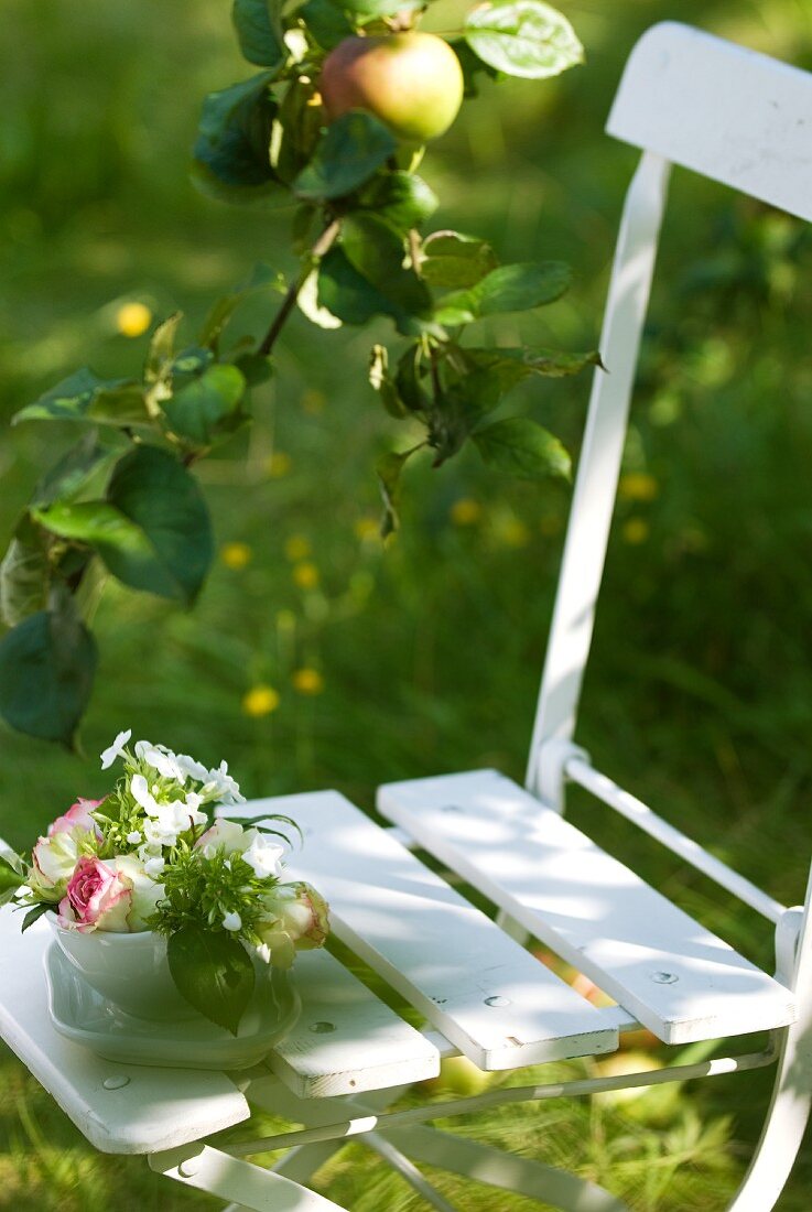 Small bowl of flowers on garden chair