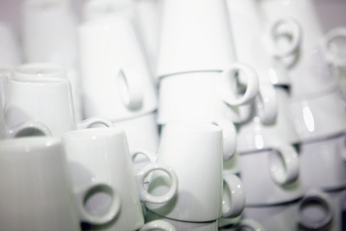 Stacks of white cups in a commercial kitchen