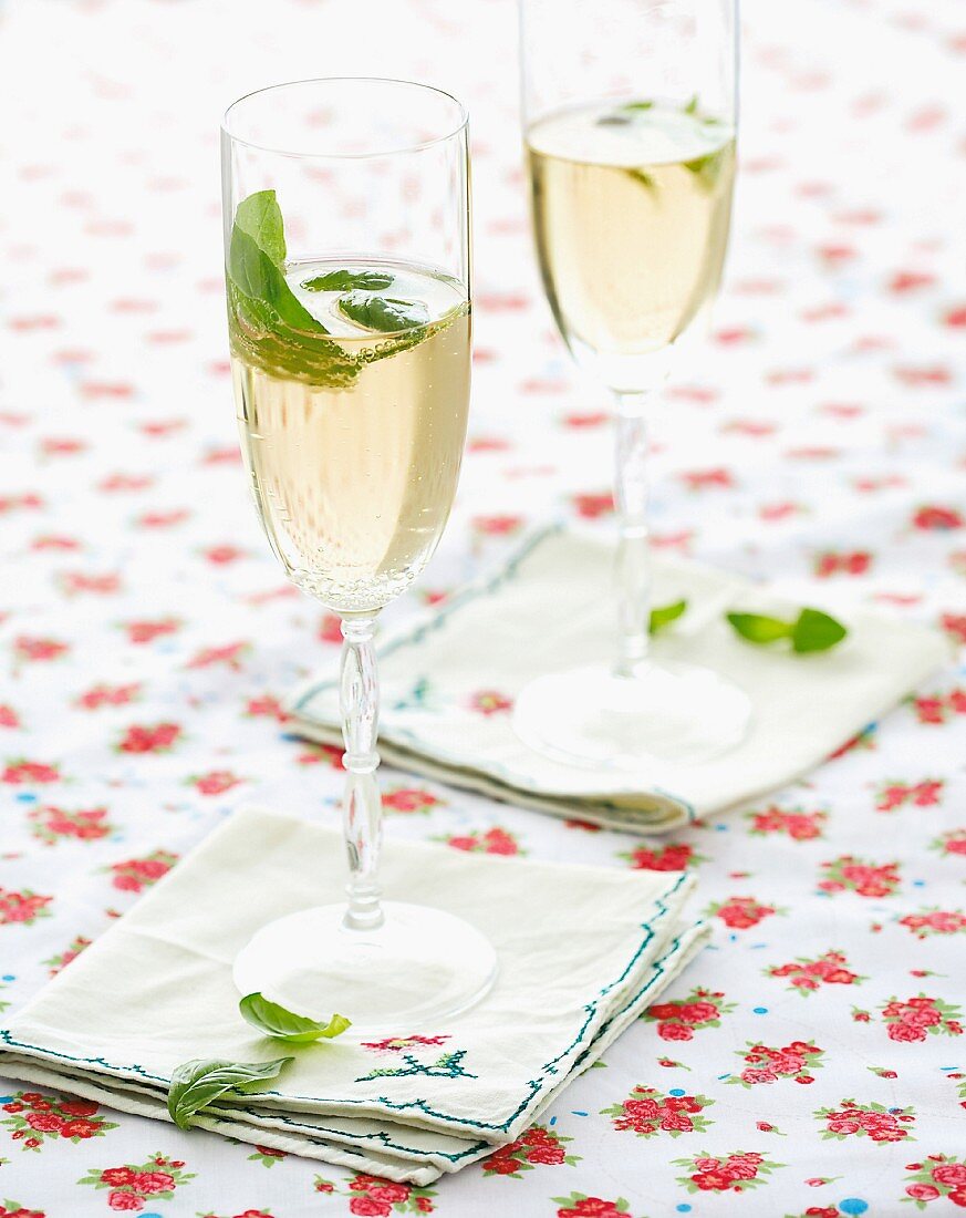 Glasses of champagne with mint leaves on a floral tablecloth
