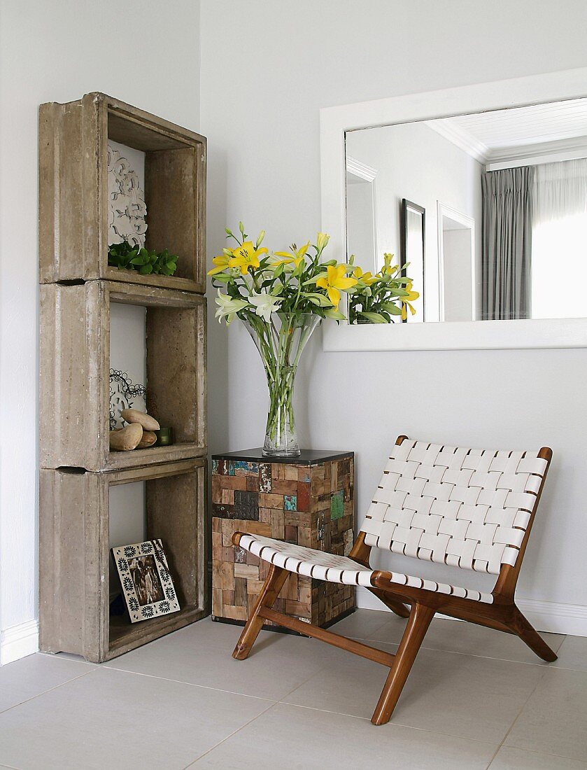 Low chair with woven fabric seat and back next to shelving made from concrete frames