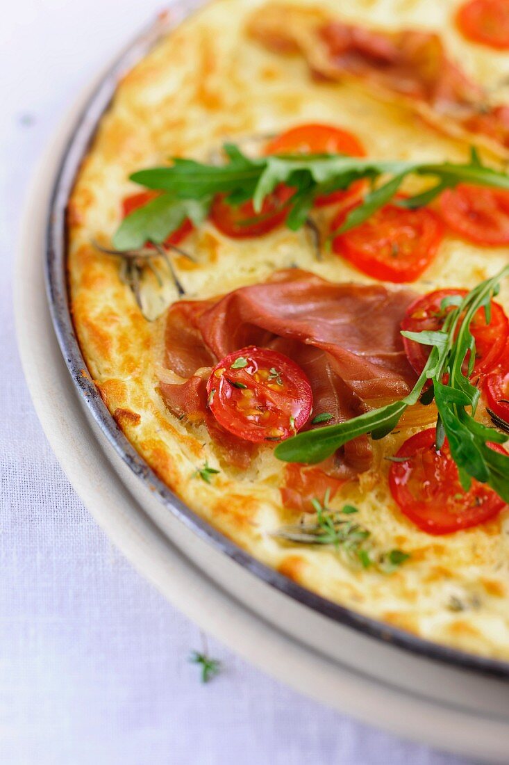 A tomato, ham and rocket pizza