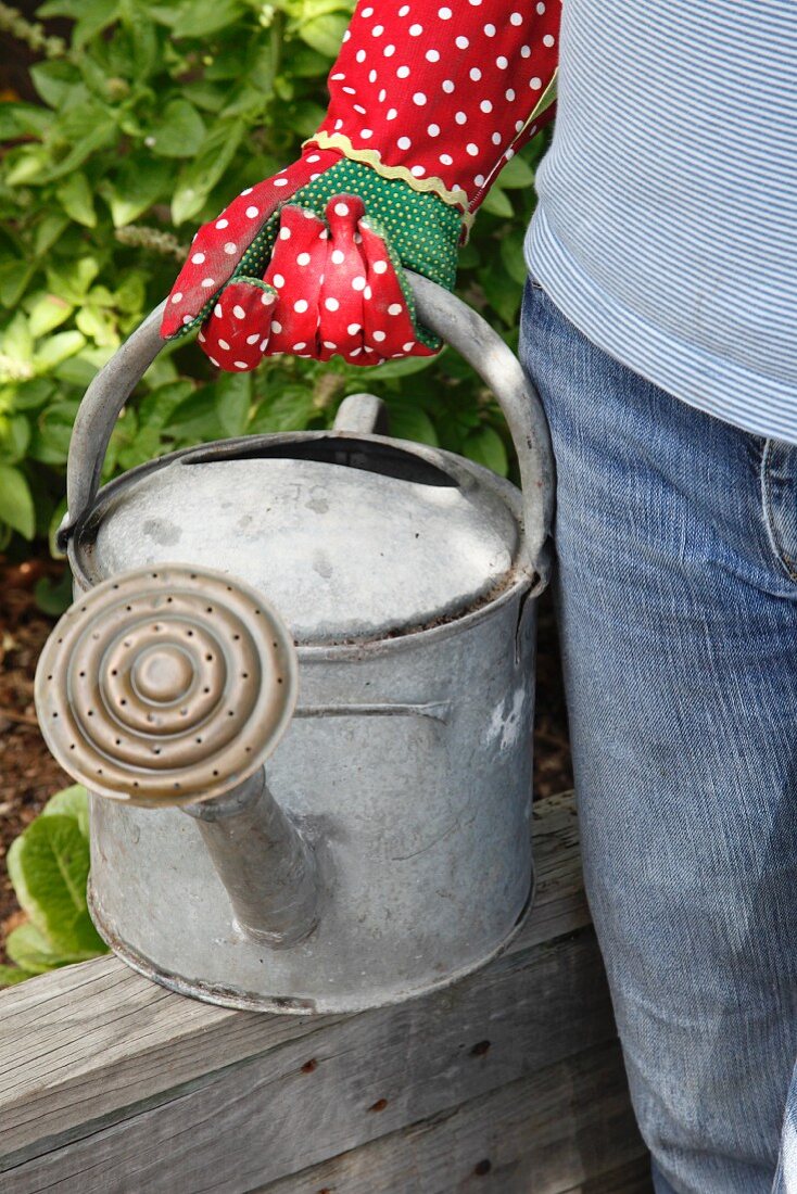 Frau mit Giesskanne im Garten